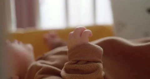 Close-up shot of unrecognizable infant lying in crib, activly moving. Macro shot Video stock 147944257