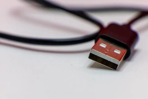 A close-up shot of a USB cable connector on a white surface. Stock Photos