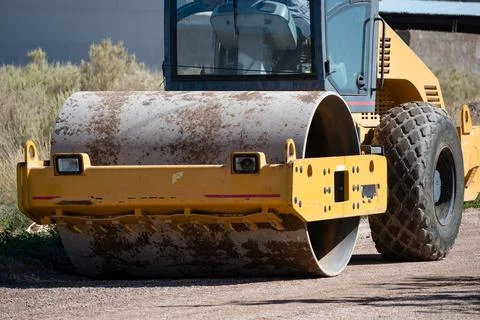 Close up shot of vibrating soil compacting roller machine at work. Stock Photos