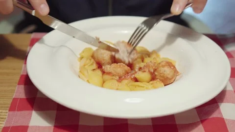 Close-up shot of a visitor eats pasta with chicken meatballs and tomato sauce. Stock-Footage 161351530