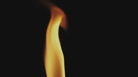 Close up shot of a warm fire flame flickering gracefully in darkness agains.. Stock Footage 337405326