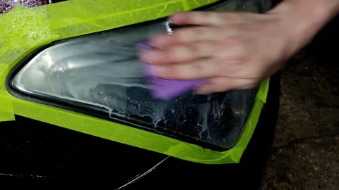 A close-up shot of washing a car headlight after sanding Stock Footage 336273906