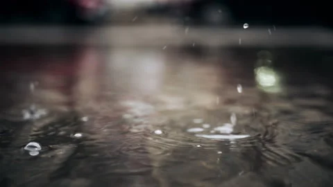 Close up shot of water drop creating circular ripple on wet surface outdoors 스톡 동영상 331010614