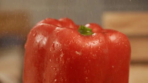 Close up shot of water falling on red bell pepper in slow motion Stock Footage 152904132