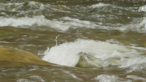Close up shot of water rippling over rocks in fast moving alpine stream Stock Footage 211892430
