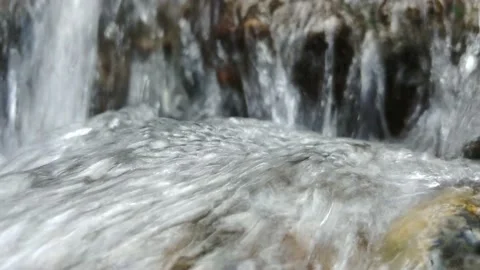 Close Up Shot Of Water Running Over Rocks And Coming To A Small Waterfall Stockbeeldmateriaal 150315349