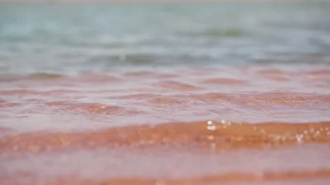Close-up shot of water waves pounding the sand, waves eroding the beach. Stock Footage 295419168