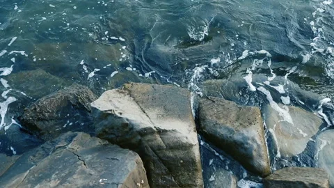 Close shot of waves rolling over rock on a beach Video stock 113962629