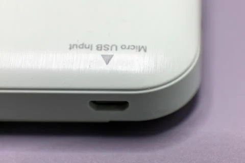 A close-up shot of a white device showing a micro USB input port and text ind Stock Photos