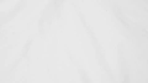 Close up shot of a white fabric surface with soft folds and a subtle texture. Stock Photos