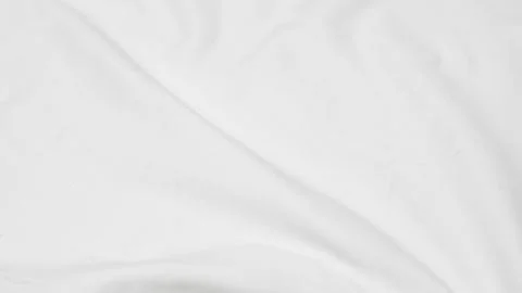 Close up shot of a white fabric surface with soft folds and a subtle texture. Stock Photos