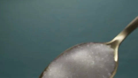 Close-up shot of white granulated sugar in a golden spoon. Stock Footage 287379700