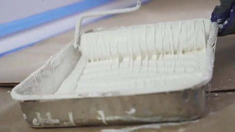 Close Up Shot of White Paint being applied on a Roller. Paint is in the Tray. Stock Footage 129140788