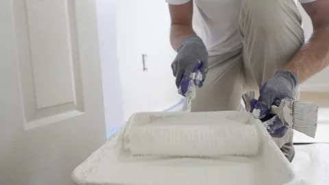 Close Up Shot of White Paint being applied on a Roller. Paint is in the Tray. 4k Stock Footage 129140846