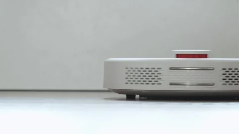 Close up shot of white robot vacuum cleaner cleans the floor from debris Video stock 243100468