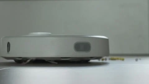 Close up shot of white robot vacuum cleaner cleans the floor from debris Video stock 244195124