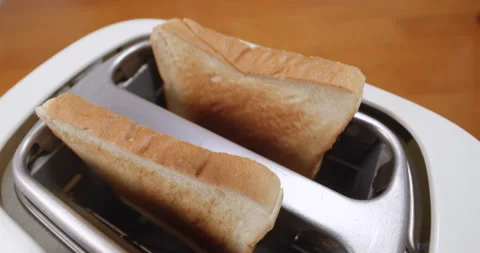 Close up shot of white sliced bread popping out of toaster Stock Footage 230142737