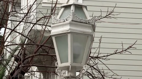 Close-up shot of an white vintage lantern set against the wooden Vídeos de archivo 340155107