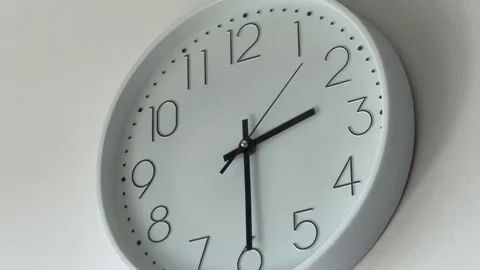 A close-up shot of a white wall clock with black numbers Stock Footage 340017005