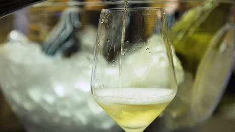 Close up shot, white wine being poured into wine glass. Stock Footage 120844365