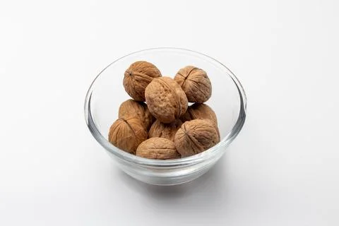 Close up shot of whole shelled walnuts kept in a glass bowl 스톡 사진
