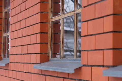 Close-up shot of a window on the side of a red brick house Stock Photos