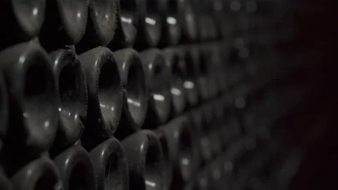 Close up shot of Wine bottles lying in stack at cellar. Glass bottles of red Stock Footage 152369080