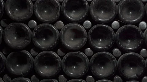 Close up shot of Wine bottles lying in stack at cellar. Glass bottles of red Stock Footage 152369810