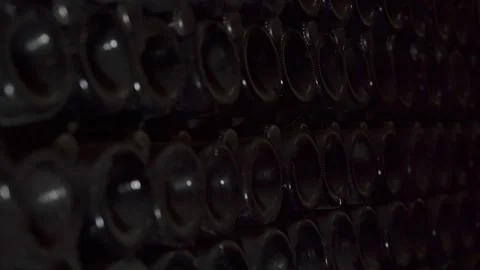 Close up shot of Wine bottles lying in stack at cellar. Glass bottles of red Stock Footage 152370023