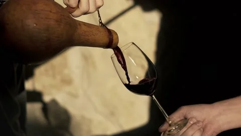 Close up shot winemaker or sommelier is pouring red wine in transparent glass Video stock 238535912