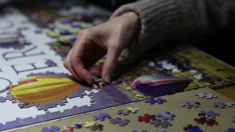 Close-up shot of a woman finding the correct position for jigsaw pieces Stock Footage 294151838