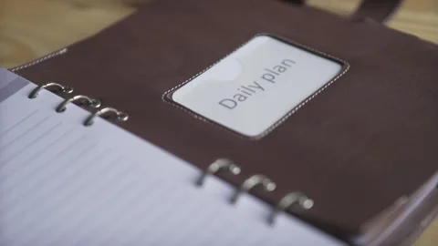 Close up shot of woman hands using sticker tag in brown leather note book pad ha Stock Footage 137539160