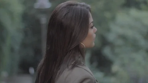 Close up shot of Woman model posing on outdoor stairway surrounded by green Stock Footage 110763083