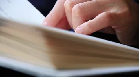 Close up shot of woman's hand reading a book indoors Stock Footage 58471097