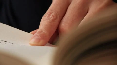 Close up shot of woman's hand reading a book indoors Stock Footage 58471185