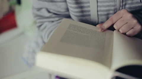 Close up shot of woman's hand reading a book indoors. Vidéo 62365519