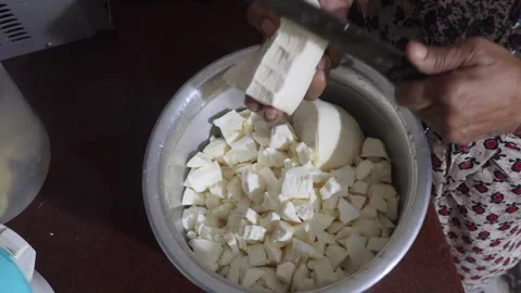 A close-up shot of a woman's hands cutting cassava into small pieces. Stock Footage 279817354