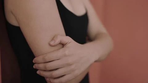 Close shot of woman's hands folded across chest in pink studio, natural beauty Vídeo Stock 168149132