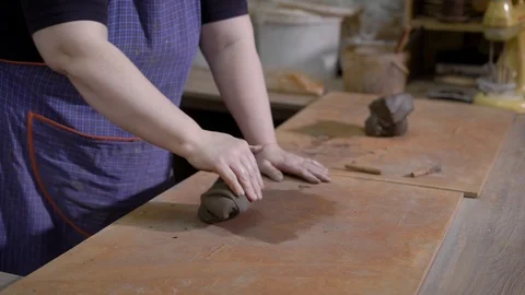 Close up shot of a woman's hands, the master makes a piece of clay softer and Stock Footage 88860849