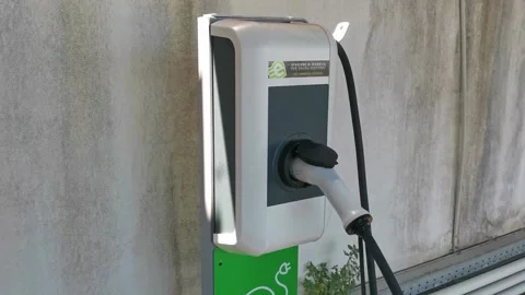 Close up shot of a woman's hands plugging in her electric car or EV at electric Stock Footage 204887018