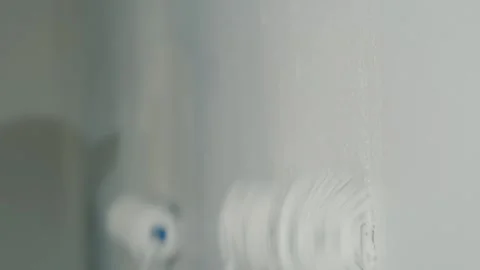Close up shot of worker painting wall with white color using paint roller b.. Stock Footage 334848564