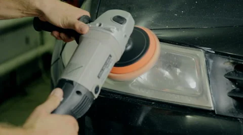 Close up shot worker polish car headlight with special tools Stock Footage 65758596