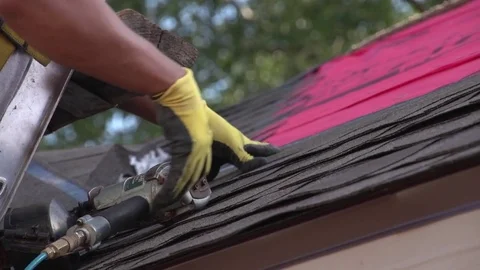 Close Up Shot of Worker Using Nail Gun to Hange Shingles on a Roof 動画素材 85358694