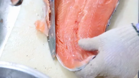 Close up shot of workers cutting salmon in the factory, salmon fillet Stockbeeldmateriaal 128594535
