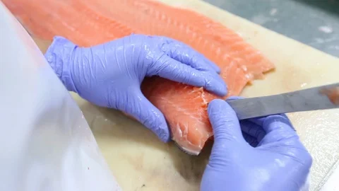Close up shot of workers cutting salmon in the factory, salmon fillet. Stockbeeldmateriaal 128594537