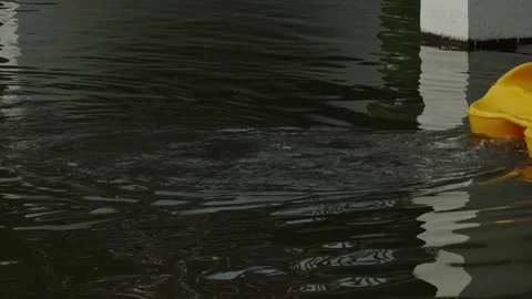 Close-up shot of yellow paddle boat moving on dark rippling lake water. Stock Footage 336004542