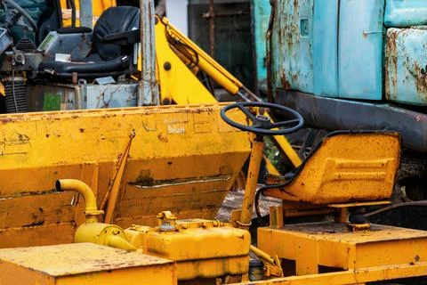 A close-up shot of the yellow rusty cab of a construction excavator Stock Photos