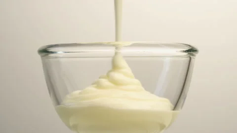Close-up shot of yoghurt being poured into a glass cup Stock Footage 221786924