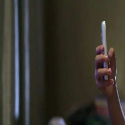 Close up shot of young boy playing on smart phone. The boy's thumbs are swiping Stockbeeldmateriaal 69555555