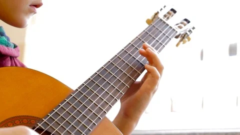 A close up shot of a young boy  practices his guitar in classroom Stock Footage 97764637